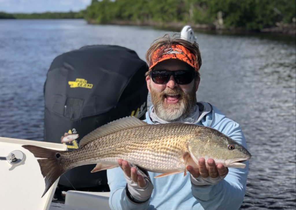 A happy angler holding Redfish caught with A2 Fishing Charters in Chokoloskee