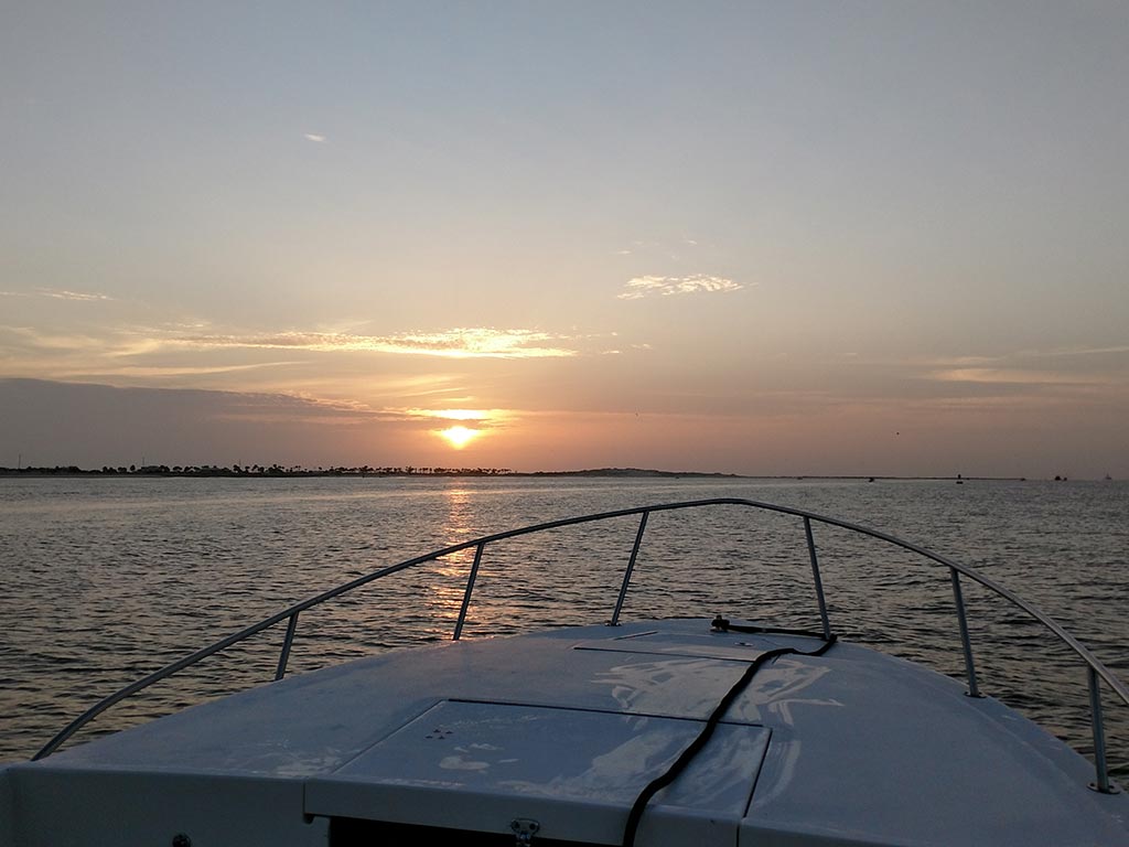 A charter boat heads out of St. John's River during sunrise.