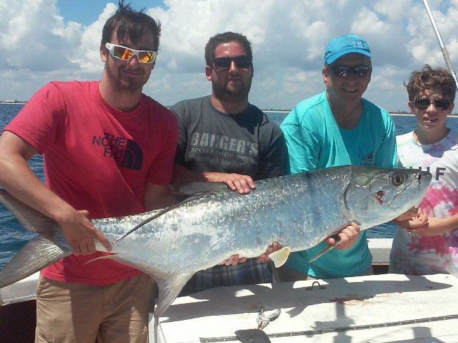 Un grupo de pescadores sostienen un sábalo atrapado pescando en Destin