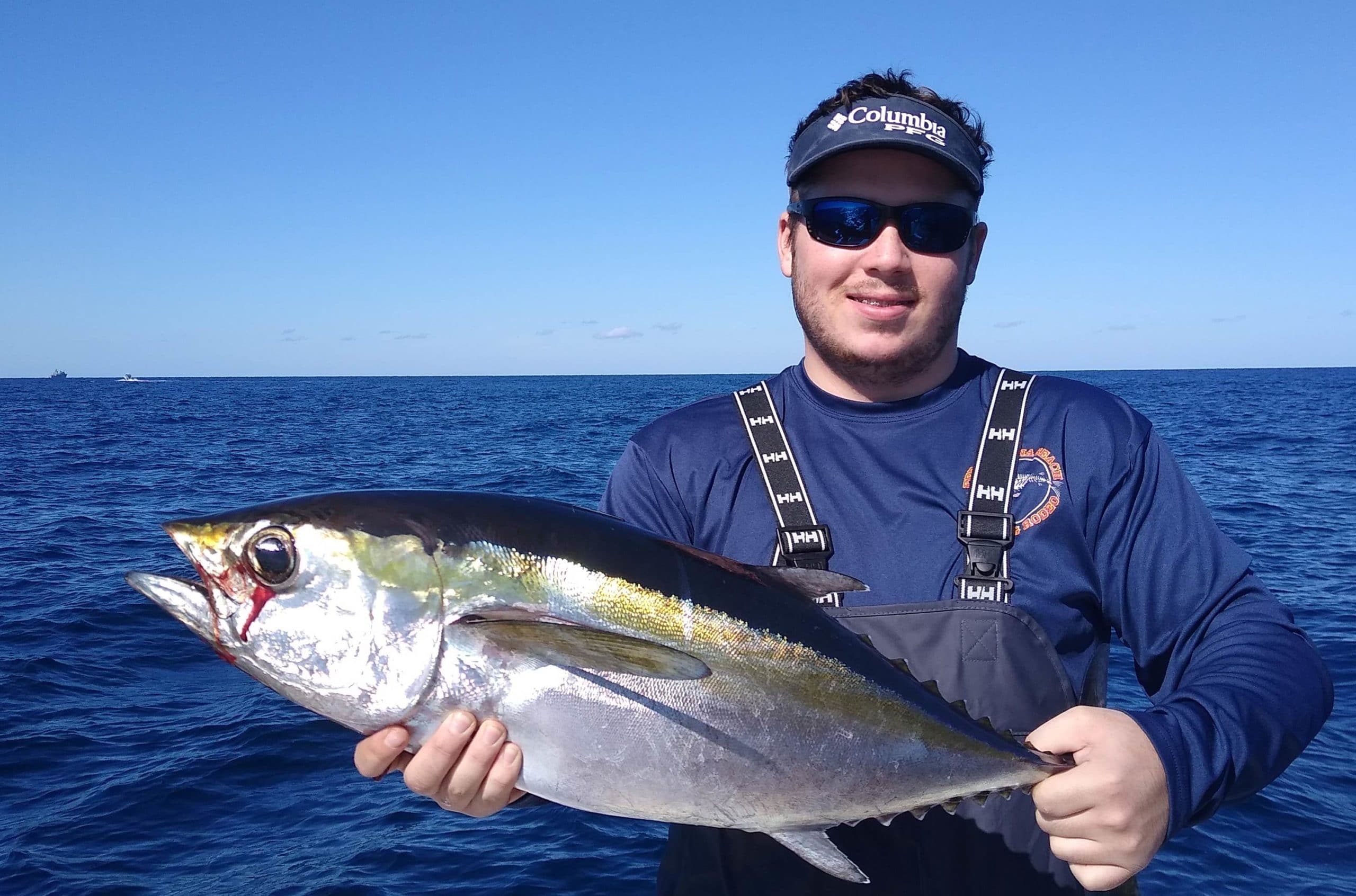 An angler on board Hott Pursuit Fishing Charters holding Blackfin Tuna, St. Augustine, Florida