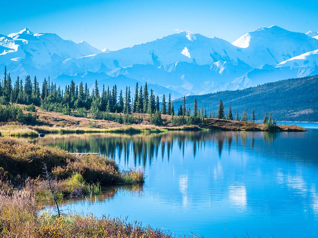 A panoramic view of Wonder Lake and Denali National Park in Alaska, with mountains in the background.