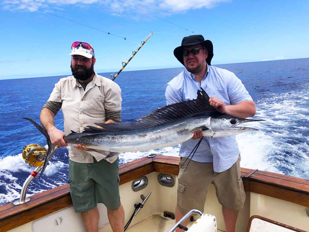 Two anglers holding Spearfish together on a boat