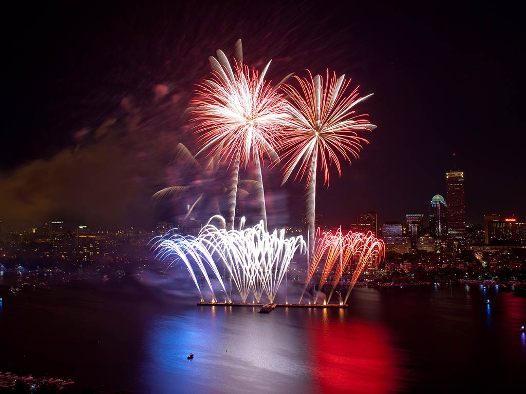 Fourth of July fireworks in Boston, with a small fishing boat visible in the foreground.