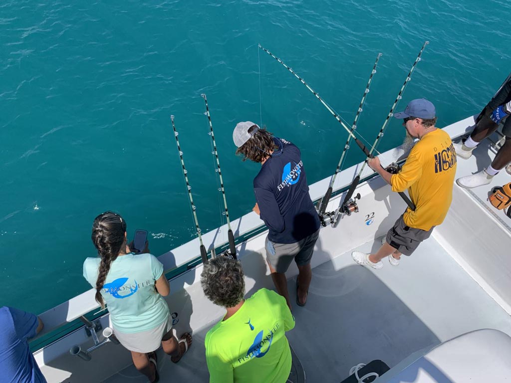 A group of anglers fishing on a party boat.