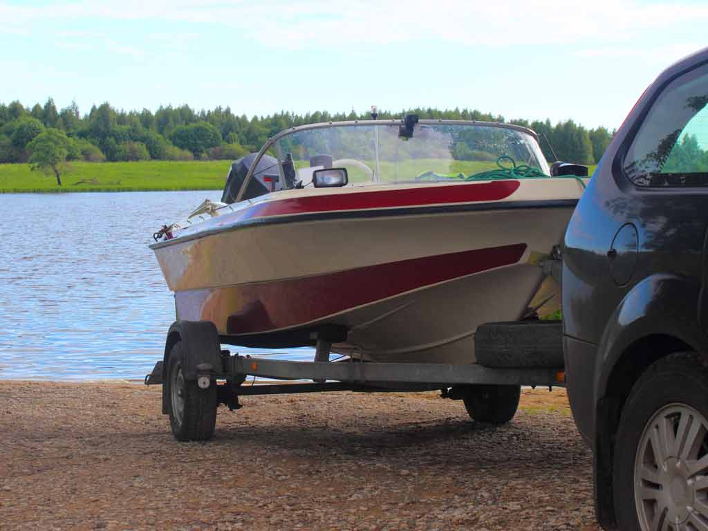 A car slowly approaching the water to release a boat from a trailer by using a boatcatch