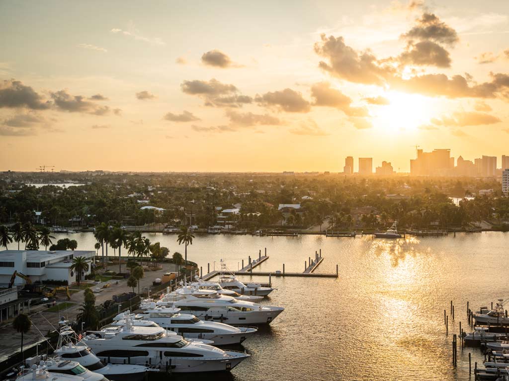 A photo of Fort Lauderdale at sunset with several docked yachts visible.