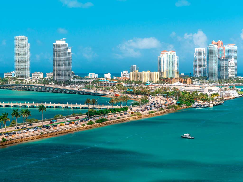 A view of the coast of Miami, Florida eith the sea on the right-hand side and the skyline in the background.