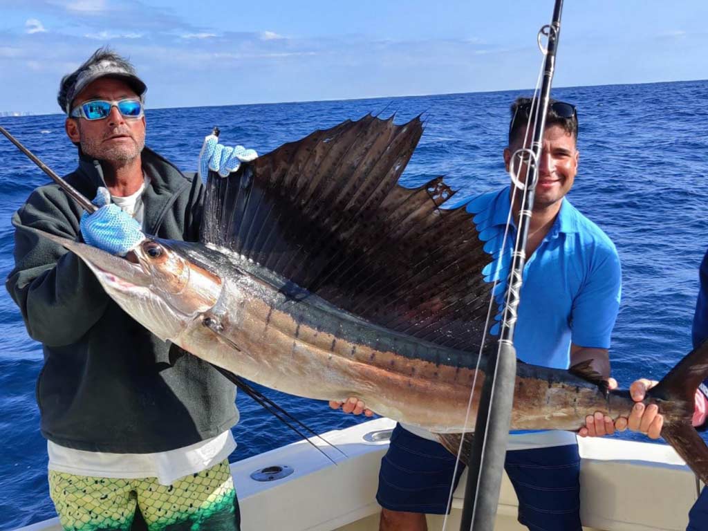 A pair of anglers holding a big Sailfish that was caught while fishing in Fort Lauderdale.