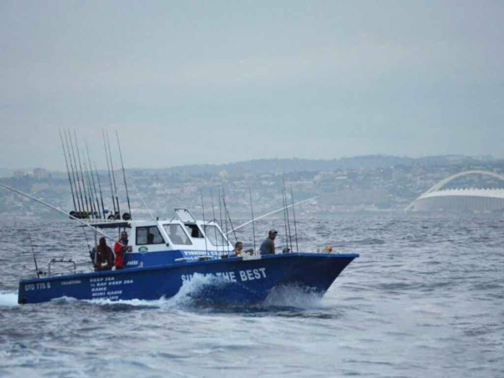 A side view of a Durban charter fishing boat and anglers in action out in the open