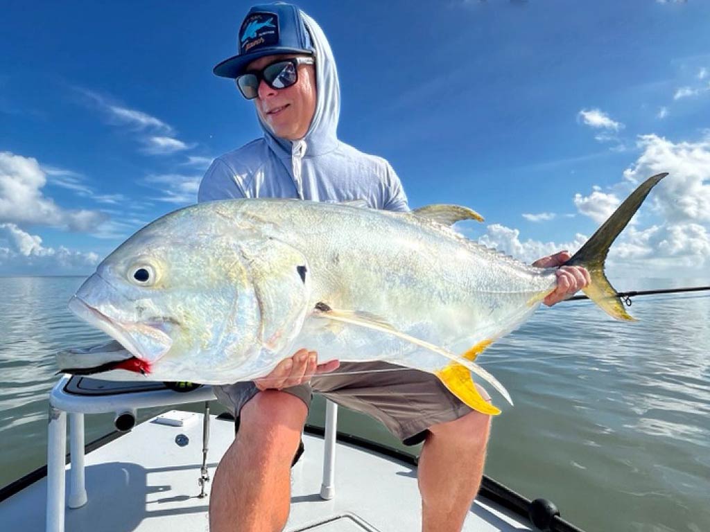 A stunning photo of an angler holding a big Jack Crevalle catch