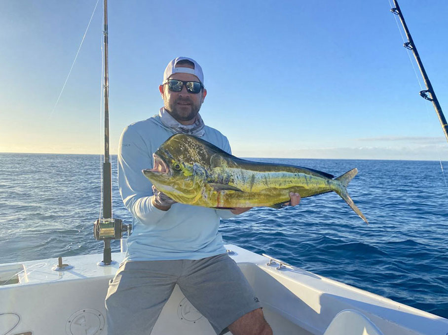 An angler holds a Mahi Mahi caught during the fishing season in Cabo