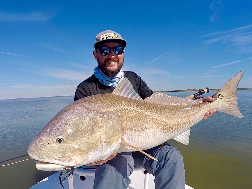 A happy angler showing off huge Redfish caught while fishing in Port Lavaca