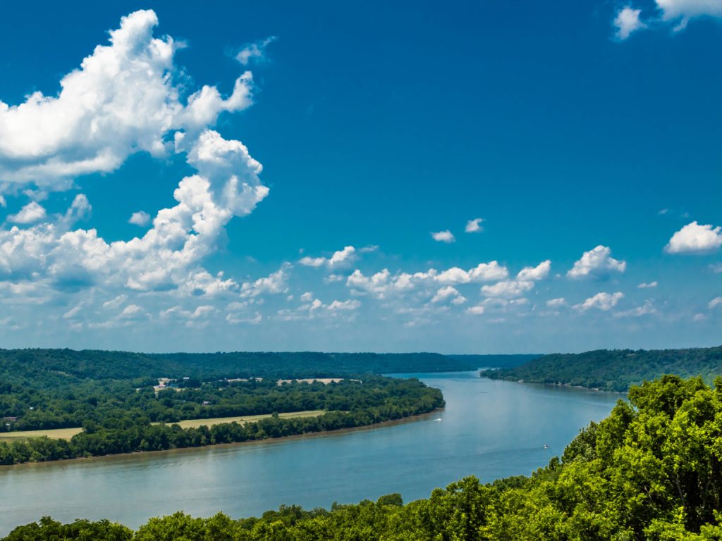 An aerial view of a bend in the Ohio River with blue sky and clouds above 