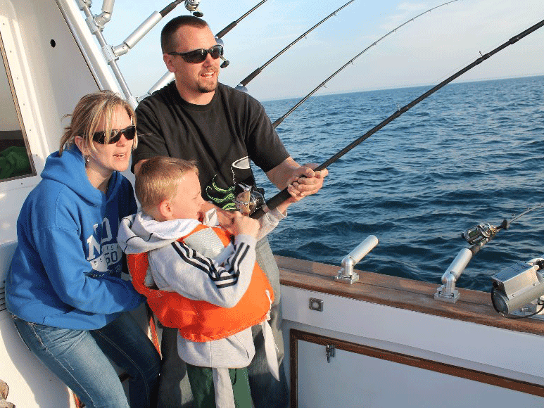 A family of anglers trolling on a boat on Lake Michigan.