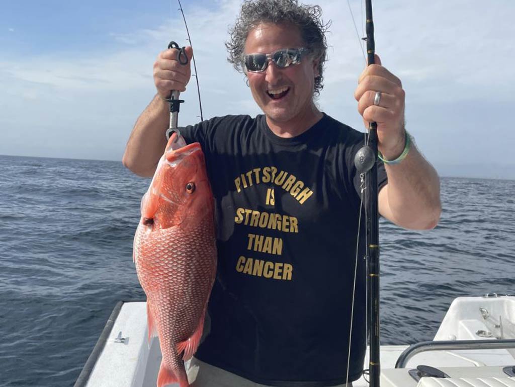 A photo of a happy angler holding Red Snapper on Captain Payton Anderson’s boat