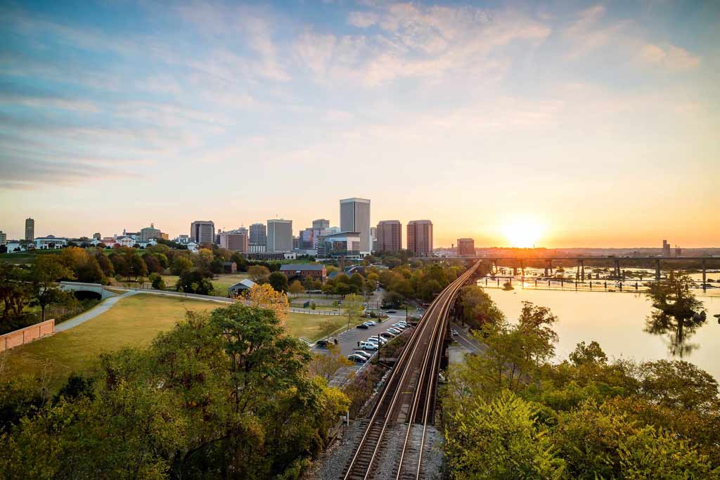 An aerial view of Richmond, Virginia at sunset with train tracks running through the centre of the picture