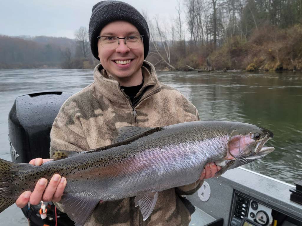 An angler holding a big Manistee River Steelhead.