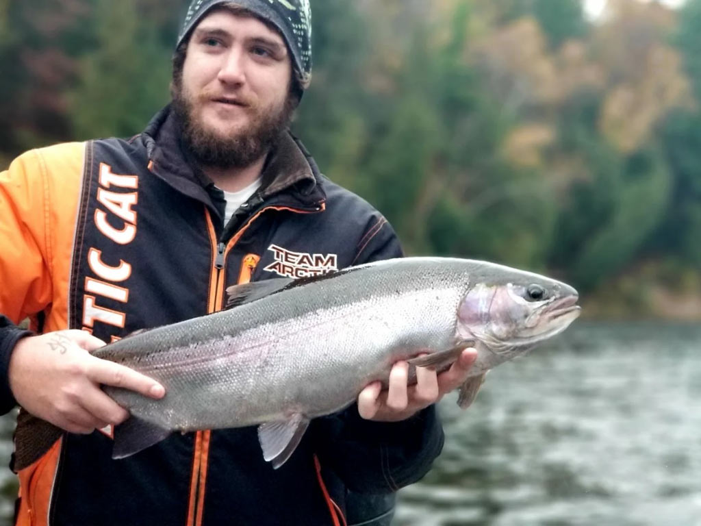 An angler holding a big Steelhead caught during the fall fishing season in Michigan.
