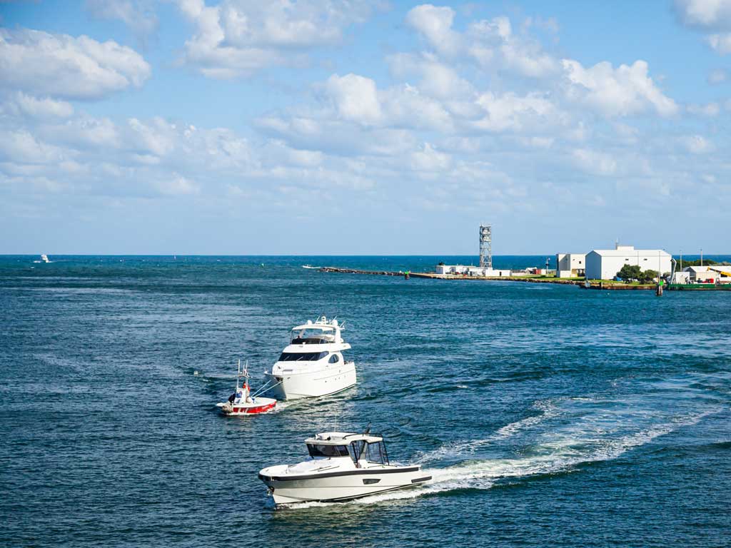 A photo of a yacht being towed by a smaller boat, along with a third vessel in the water.