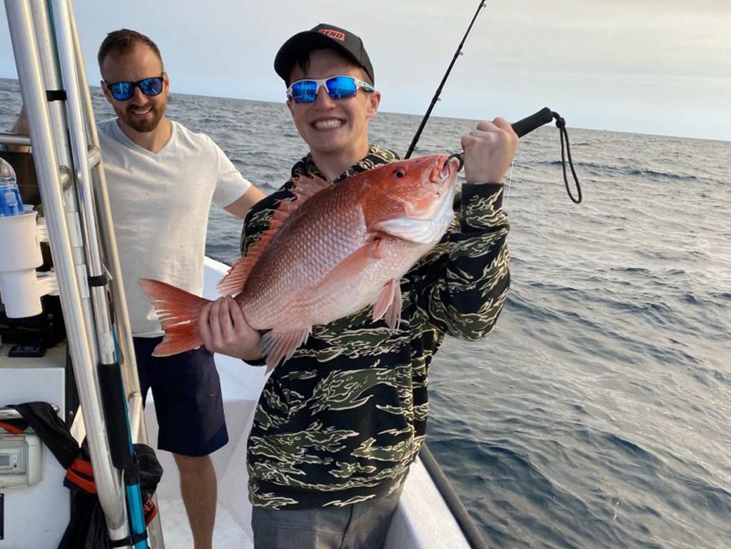 A photo of satisfied angler holding Red Snapper he caught while fishing with Captain Payton on Souther Country Charters boat