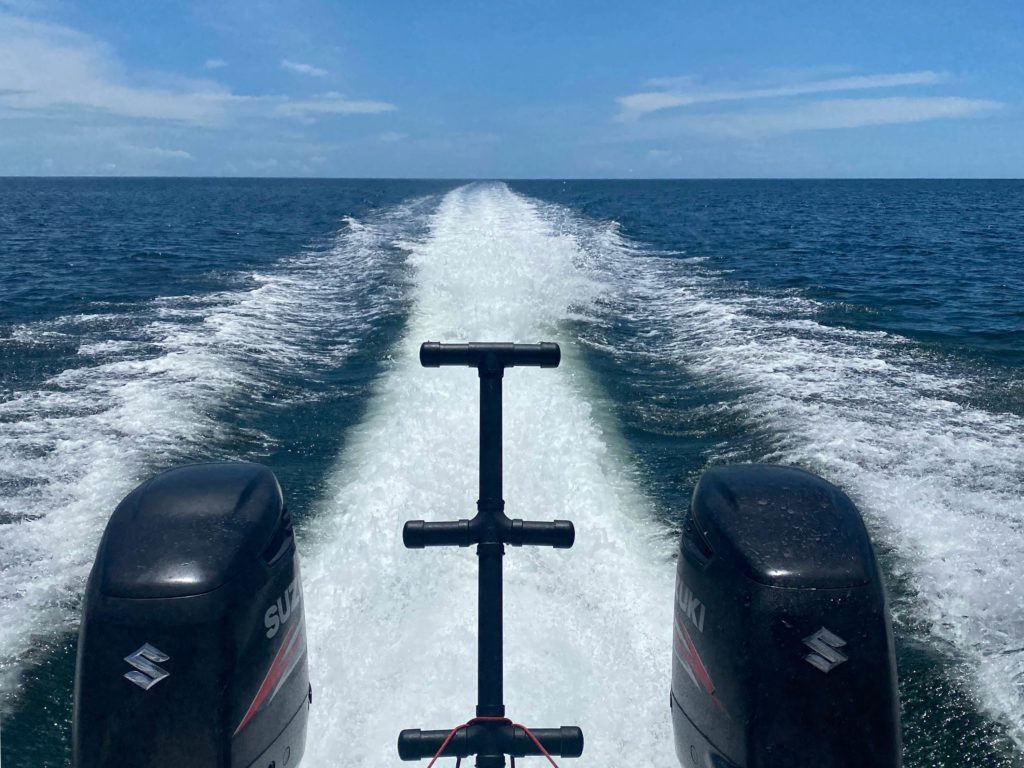 A picture of a charter fishing boat showing two Suzuki engines on the way to or from the offshore fishing grounds in Cape Canaveral, Florida