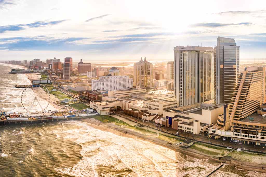 An aerial view of downtown Atlantic City on a sunny day, with the pier and pleasure park on the left-hand side of the image