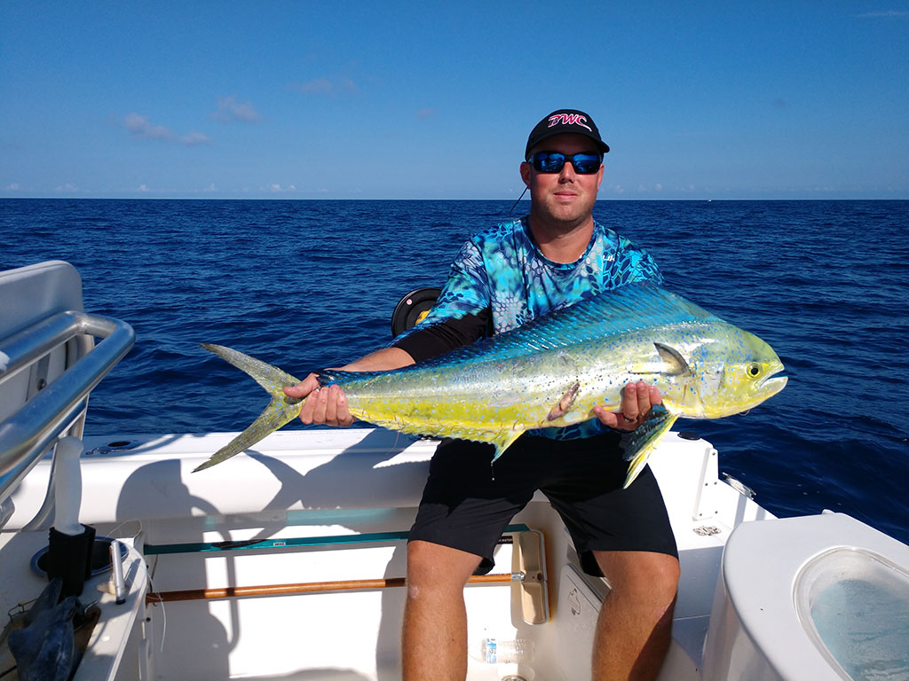 An angler holds a colorful Mahi Mahi on a North Carolina fishing charter