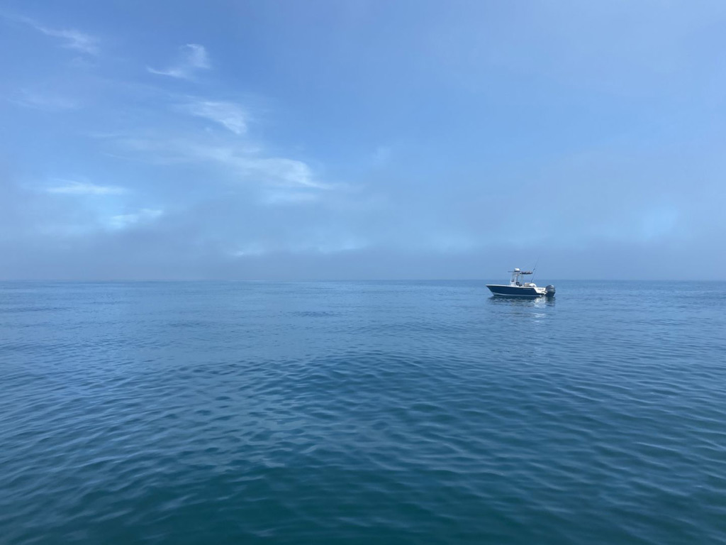 A distant view of a lone Ocean City charter boats on the calm sea.