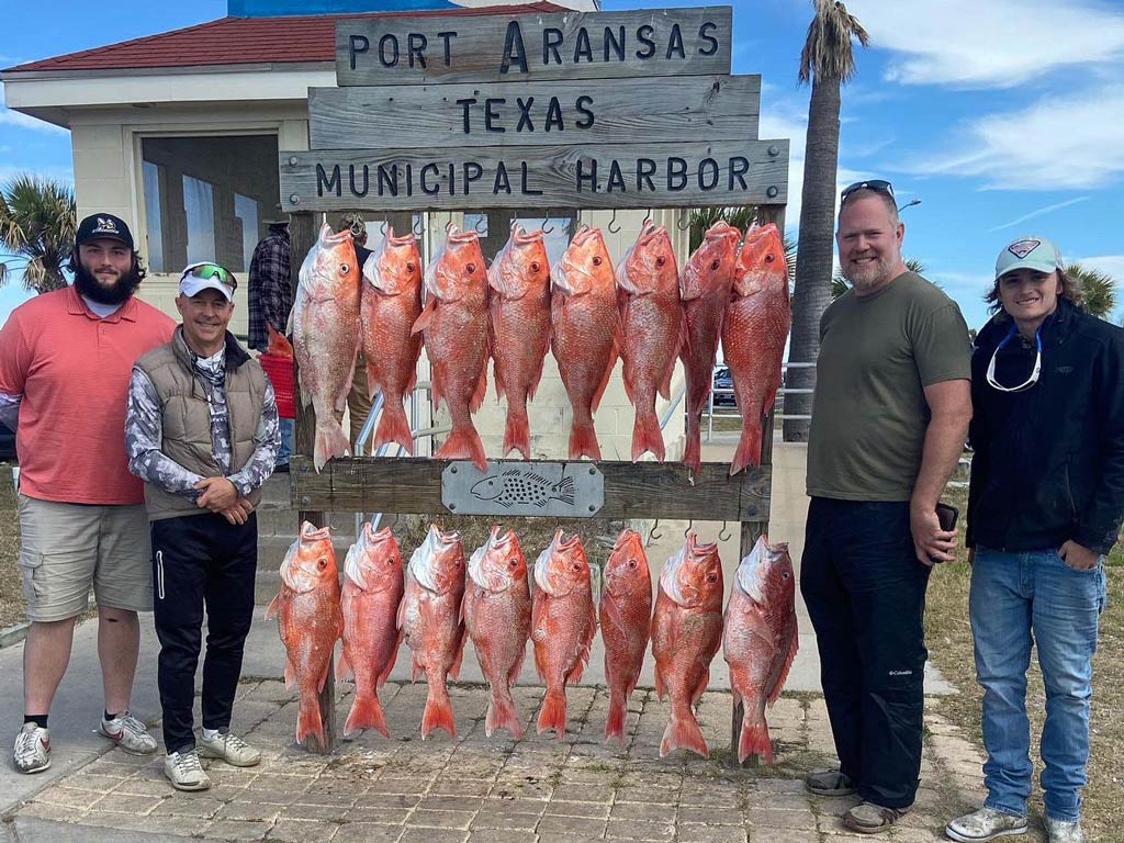 A group photo taken in Port Aransas of anglers showing off their Red Snapper catch on the dock