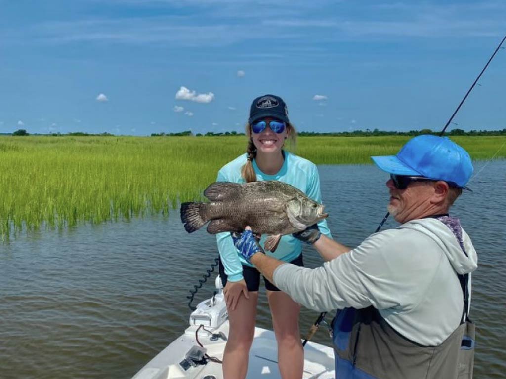 A photo of an angler and captain standing on a Jekyll Island fishing charter with their Tripletail catch