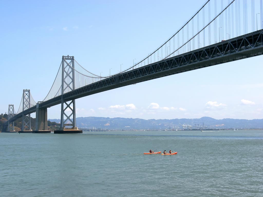 Kayakers passing under the Bay Bridge.