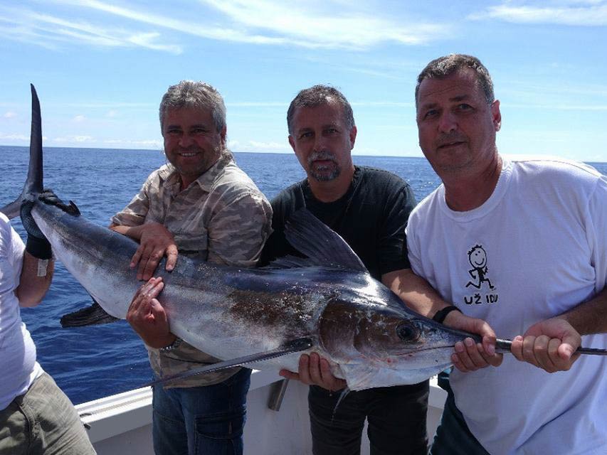 Three anglers holding a Marlin caught offshore in the Azores