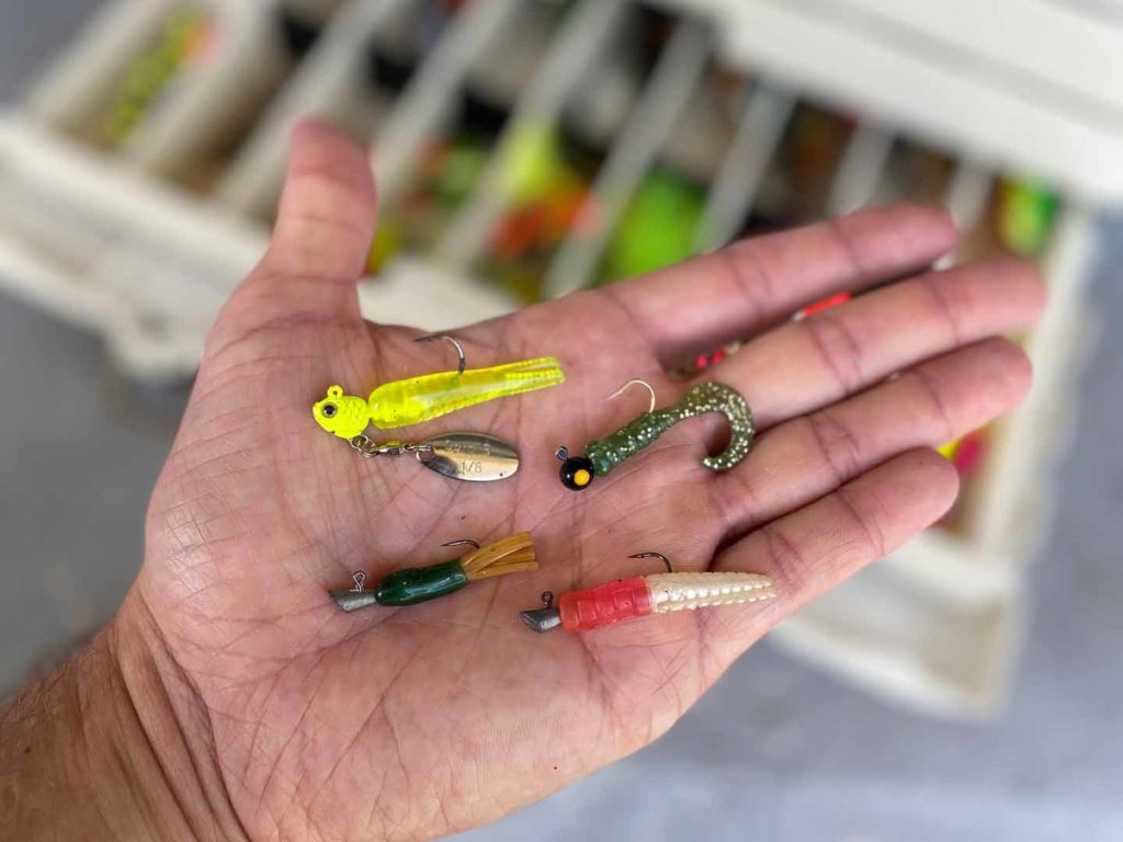 A variety of fishing lures in a man's hand