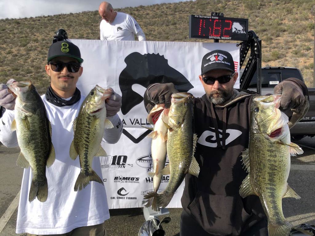 A photo of two anglers showing off their catches during a Bass tournament in the California Delta