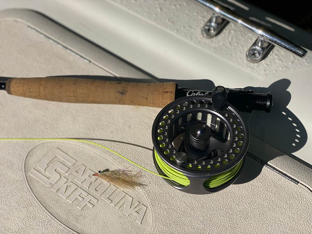 A closeup of a fly fishing reel on a Carolina Skiff boat