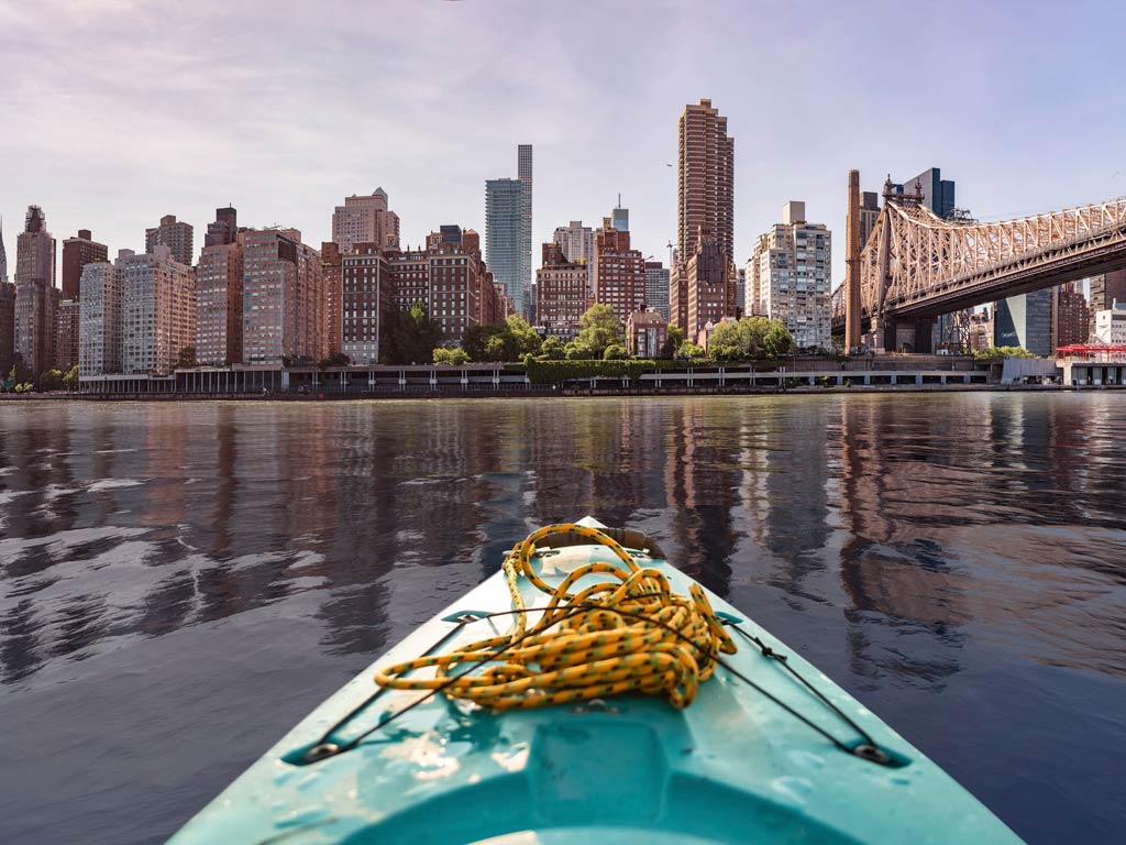 A photo taken from a kayak facing New York City’s skyscrapers and a bridge