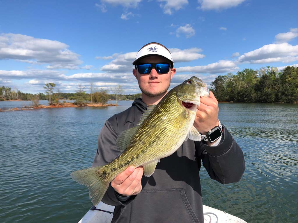 An angler posing with a big Largemouth Bass he caught fishing in Santee Cooper lakes in South Carolina.