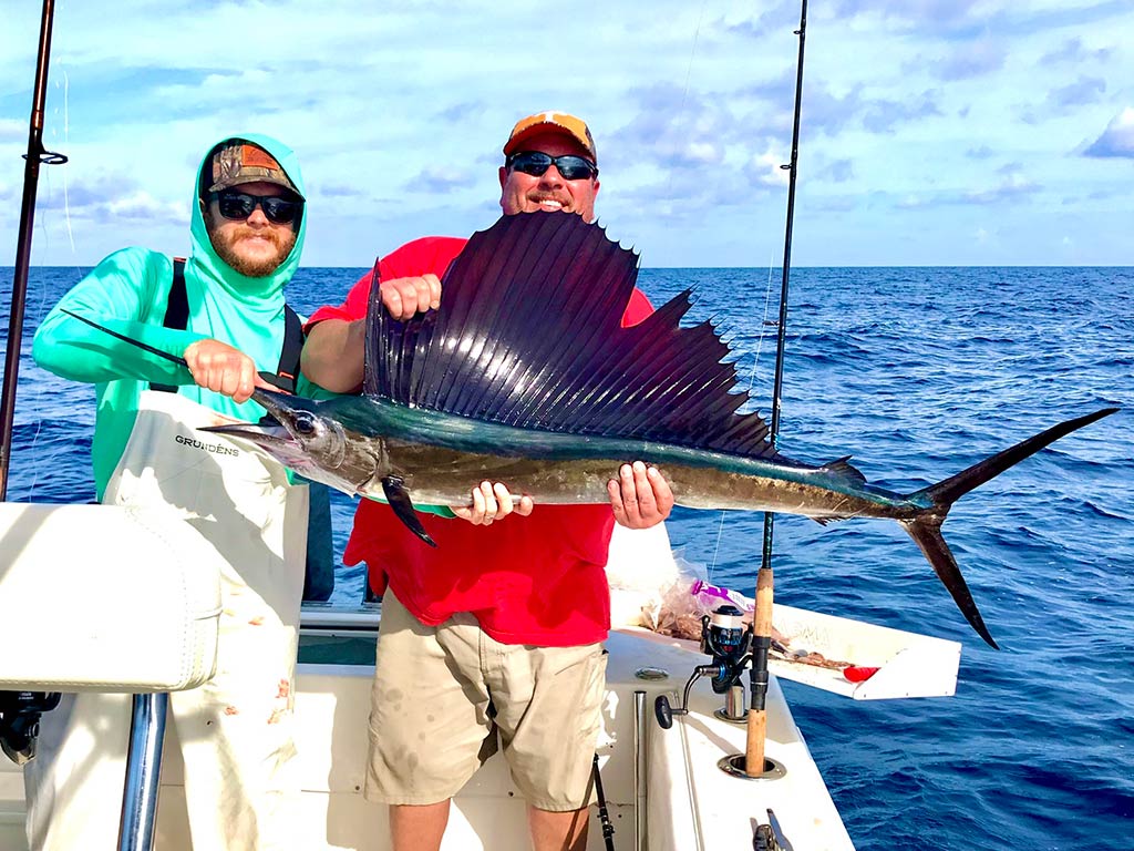 Two anglers on a deep sea fishing charter from Cortez holding a large Sailfish
