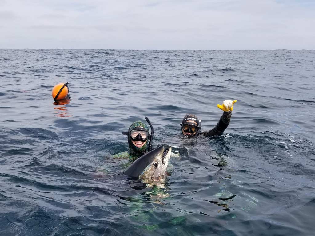 Two spearos posing with a Tuna they caught diving offshore.