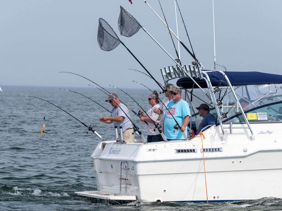 A group of anglers standing on a boat, fishing for Walleye on a Great Lake in Michigan