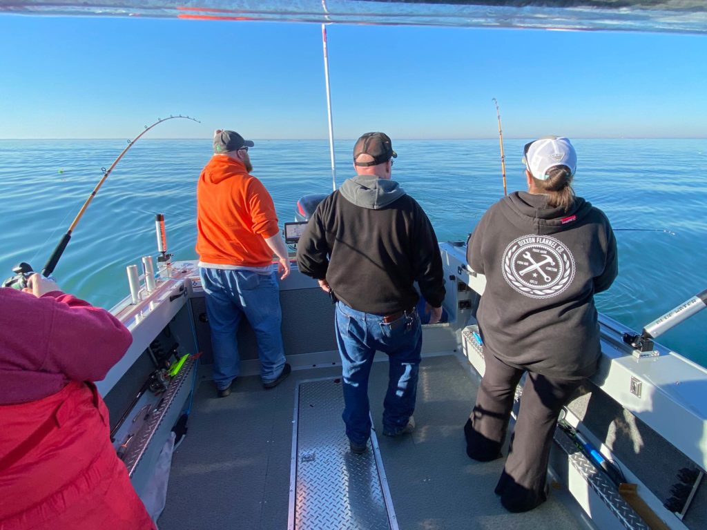 A group of Great Lakes anglers standing on a charter fishing boat, fishing for Walleye, Michigan