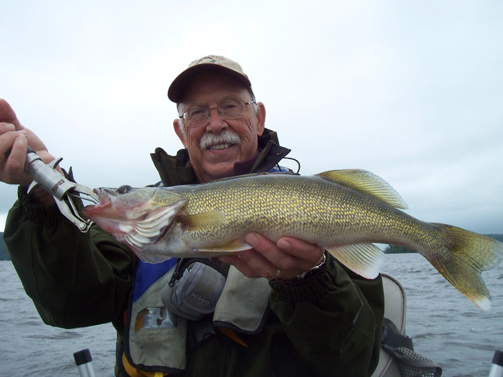 A smiling angler holds up a Walleye he caught during a fishing trip in Wisconsin.