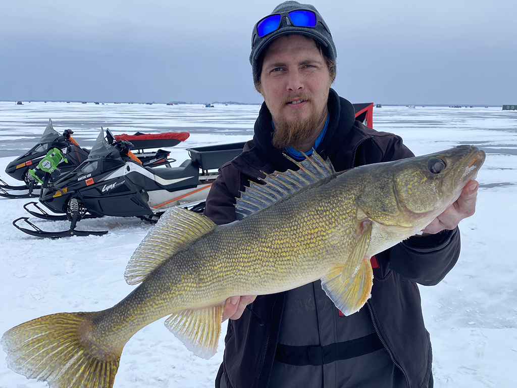 An angler poses with a Walleye he caught on an ice fishing trip in Wisconsin.