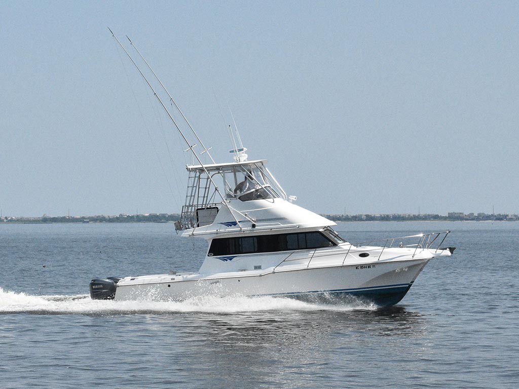 A charter fishing boat cruising on the water.