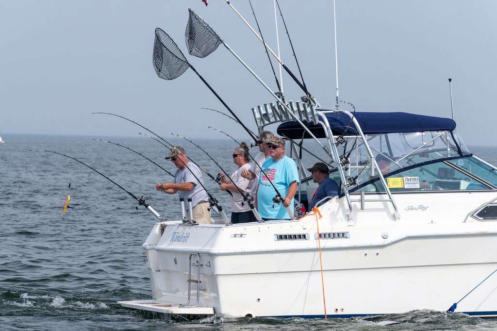 Older fishermen on a fishing boat holding their rods