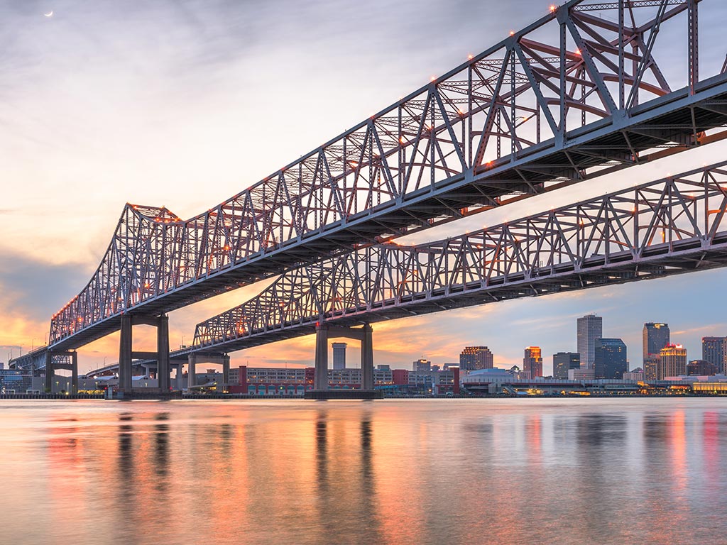 Crescent City Connection Bridge in New Orleans at sunset, as seen from the riverside. 