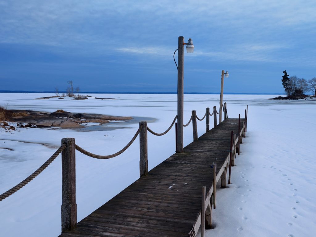 Lake Nipissing dock on still frozen water after a spring snowstorm in North Bay Ontario at sunset 