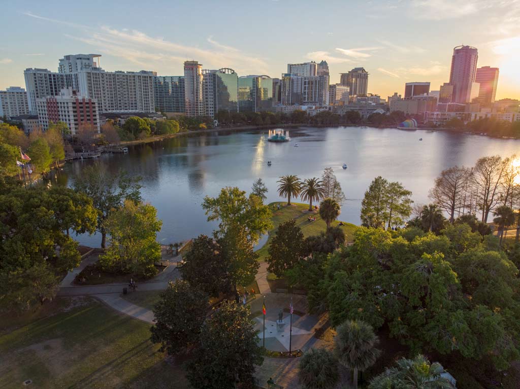 An well-ventilated view of Orlando at sunset, with one of its famous lakes as the focal point of the image.