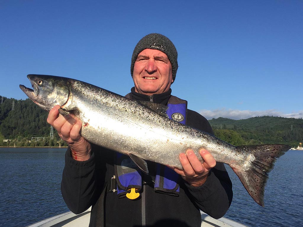 A happy angler holds a Salmon he caught near Astoria.