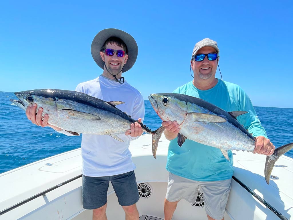 Two anglers holding a Blackfin Tuna they each caught on a trolling trip offshore from Marco Island.